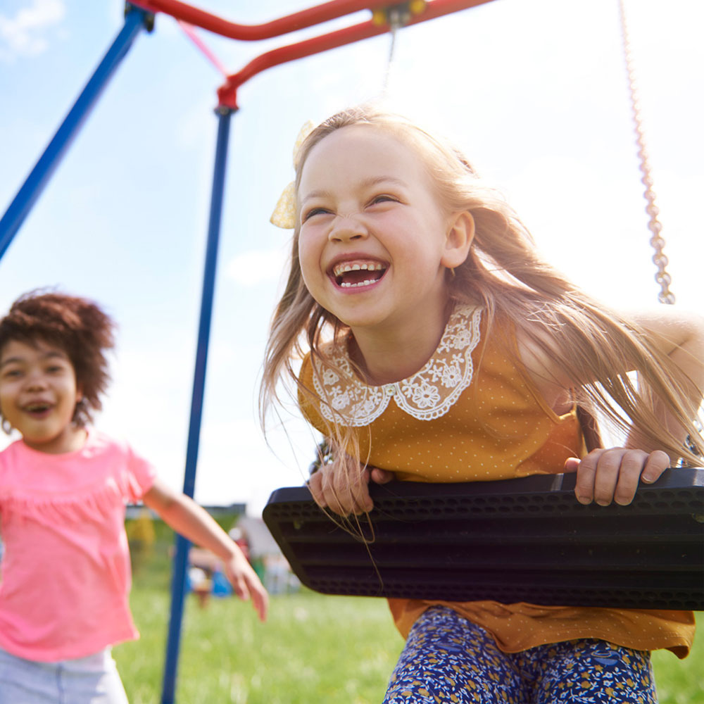 Bambine che si divertono con altalena da giardino