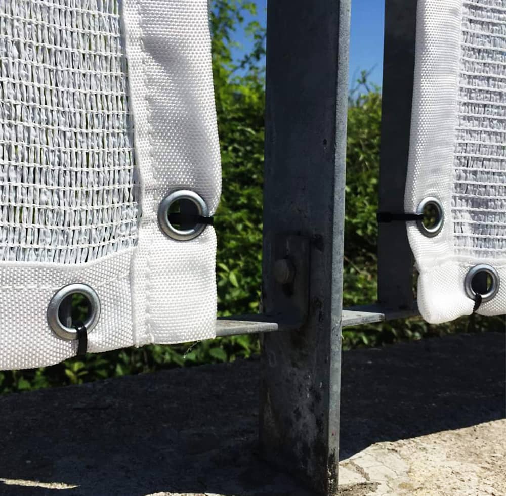 Occhielli di una rete ombreggiante bianco legati con fascette di plastica